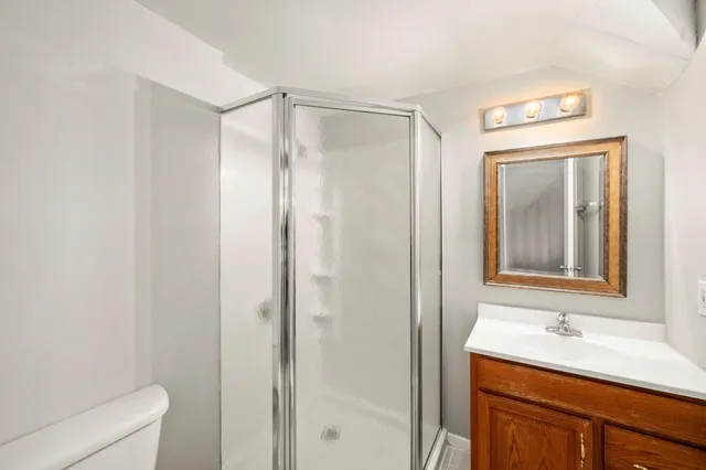 a bathroom with a shower sink vanity and mirror