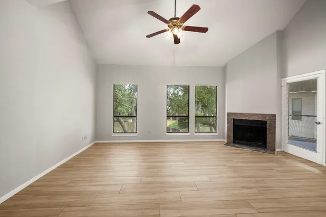 a view of empty room with wooden floor and fireplace