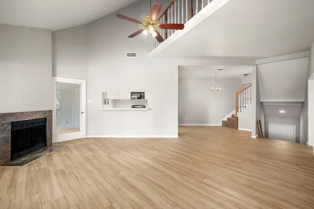 a view of a livingroom with wooden floor and a kitchen space