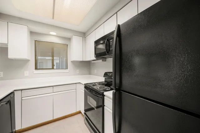a kitchen with a refrigerator and a stove top oven