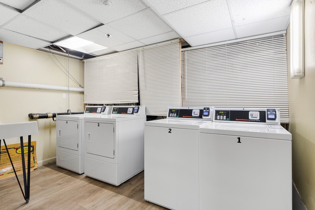 80 Wingate Street, Unit 4C Haverhill, MA 01832 - Photo 18 of 27 a view of washer and dryer with wooden cabinets