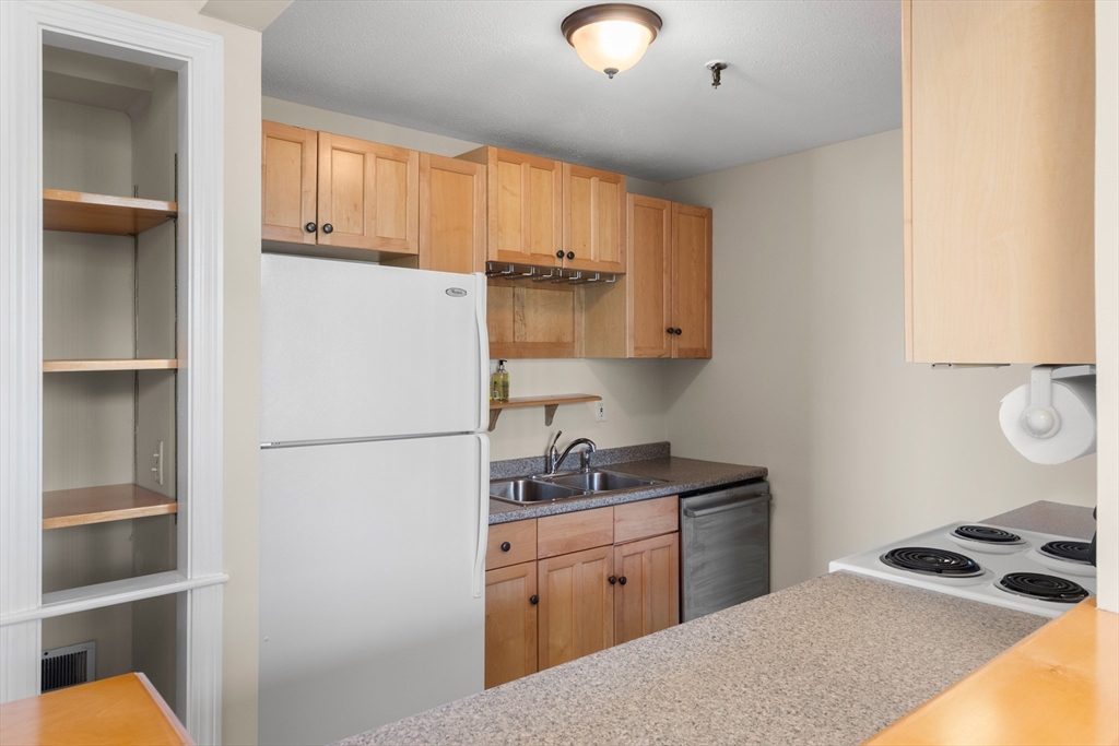 80 Wingate Street, Unit 4C Haverhill, MA 01832 - Photo 6 of 27 a kitchen with a refrigerator and a stove top oven