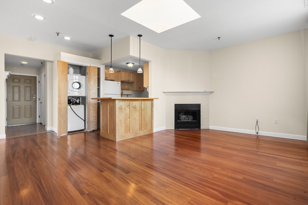 80 Wingate Street, Unit 4C Haverhill, MA 01832 - Photo 9 of 27 a view of a kitchen with a fridge wooden floor and a fireplace