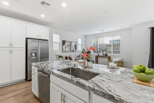 a kitchen with granite countertop white cabinets and stainless steel appliances