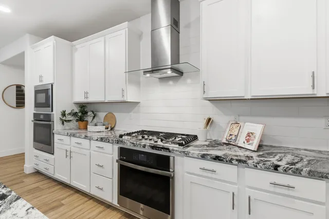 a large kitchen with granite countertop a lot of counter space