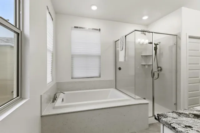 a spacious en suite bathroom with double sink and a mirror