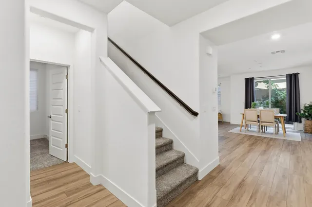a living room with furniture kitchen and a wooden floor