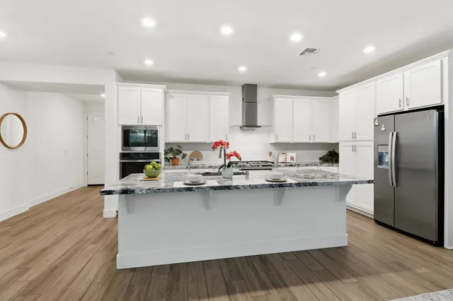 a kitchen with stainless steel appliances granite countertop a sink stove and refrigerator
