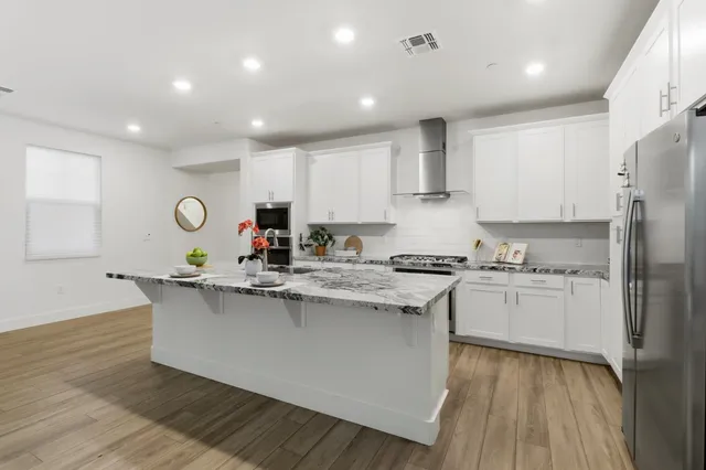 a kitchen with stainless steel appliances a stove top oven and refrigerator