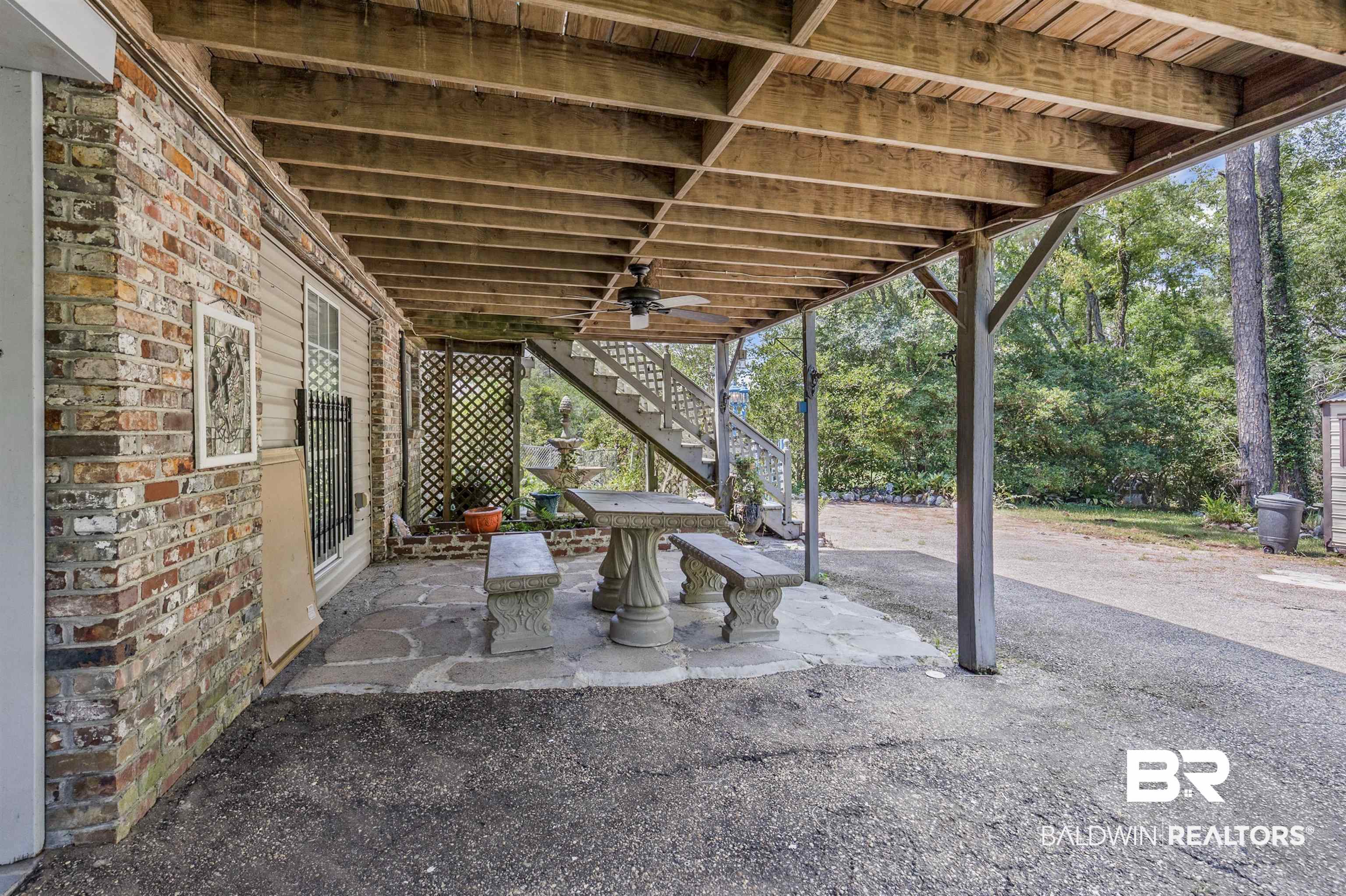 36 Ridgeview Drive Mobile, AL 36611 - Photo 19 of 20 View of patio with stairs, a ceiling fan, and outdoor table and bench