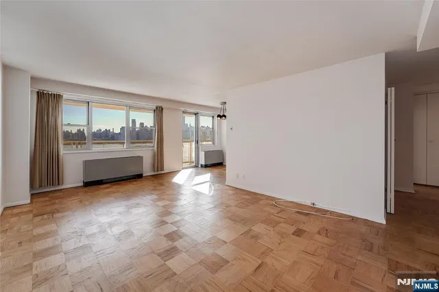 a view of empty room with a kitchen