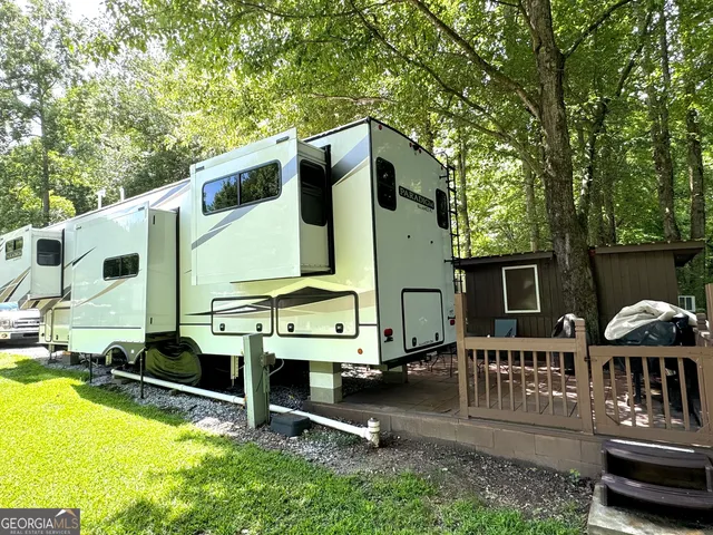 a view of a patio with table and chairs with wooden floor and plants