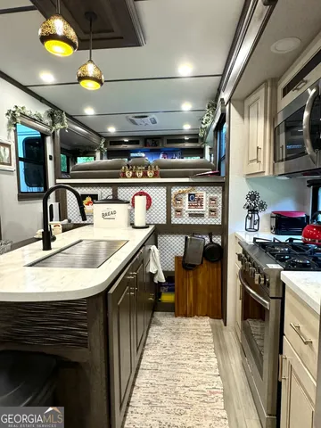 a kitchen with stainless steel appliances kitchen island granite countertop a refrigerator and a sink