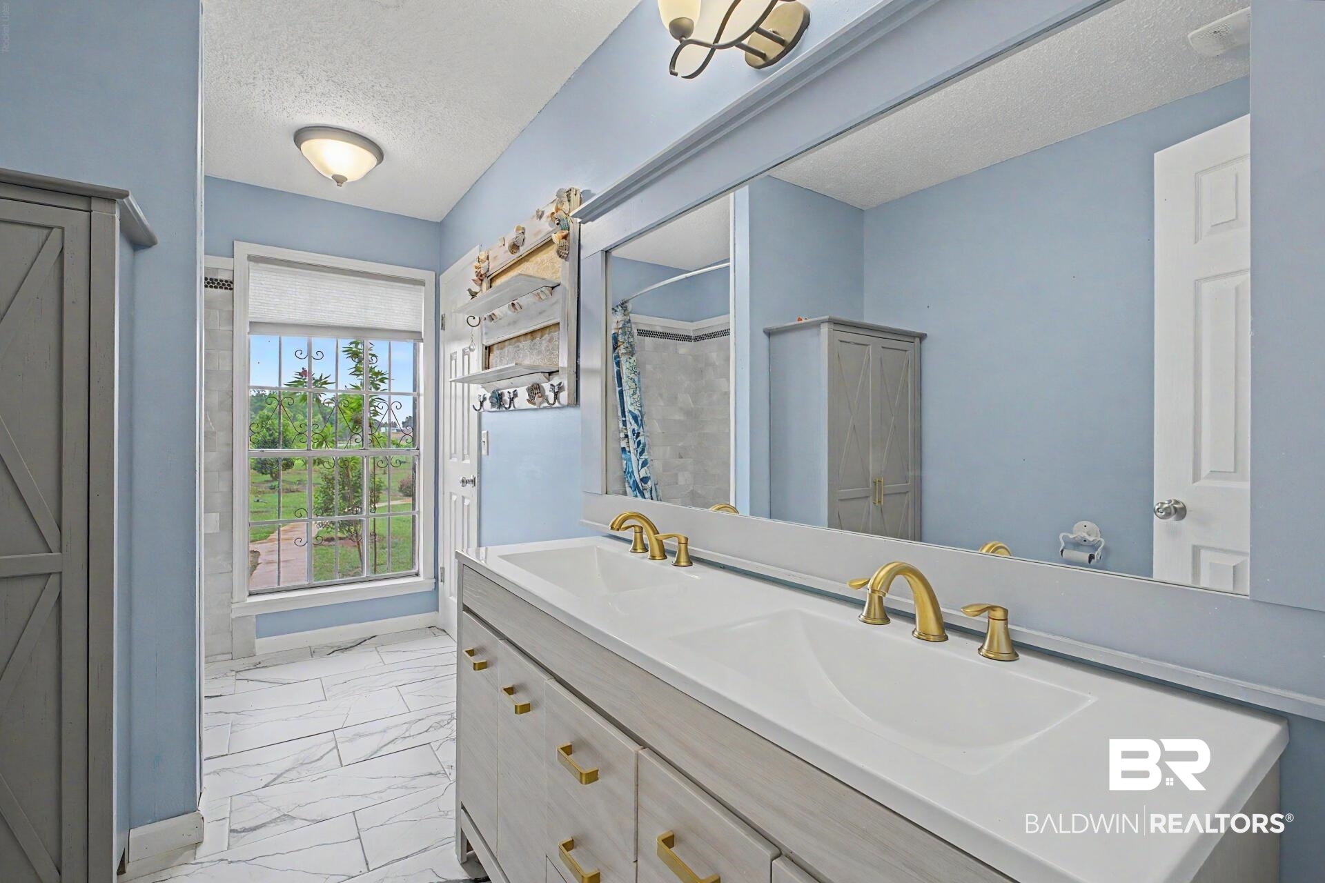 3791 Robinsonville Road Atmore, AL 36502 - Photo 38 of 47 Double vanity with dual white undermount sinks, gold-finish faucets, and a light wood-finish cabinet with gold hardware