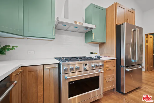a kitchen with stainless steel appliances granite countertop a refrigerator stove and sink