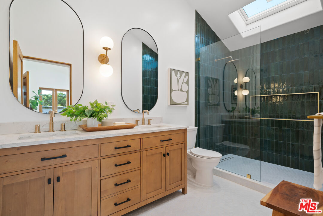 5252 Range View Avenue Los Angeles, CA 90042 - Photo 24 of 41 a bathroom with a double vanity sink toilet mirror and shower