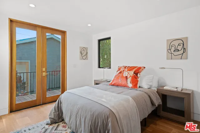 a bedroom with a bed and a lamp with the wooden floor