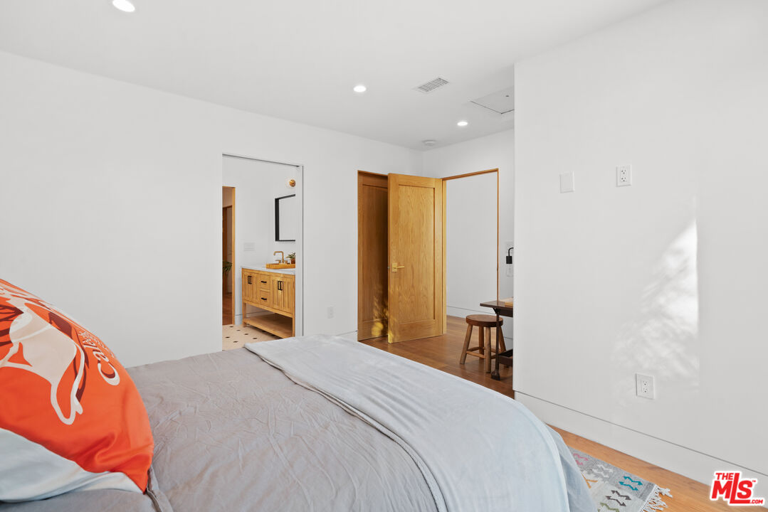 5252 Range View Avenue Los Angeles, CA 90042 - Photo 31 of 41 a bedroom with a large bed and a chandelier