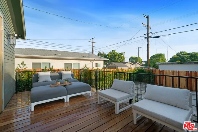 a view of a patio with couches chairs and wooden floor