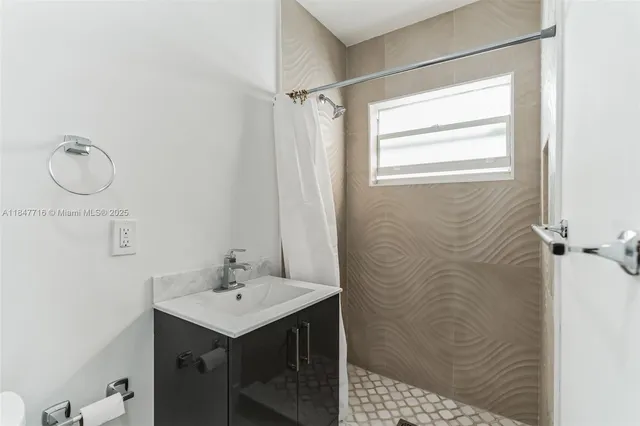 a bathroom with a sink a light fixture and a shower
