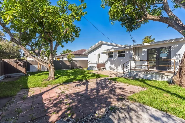 a view of a house with backyard and sitting area