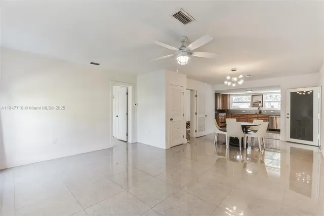 a view of a dining room with furniture a kitchen and chandelier
