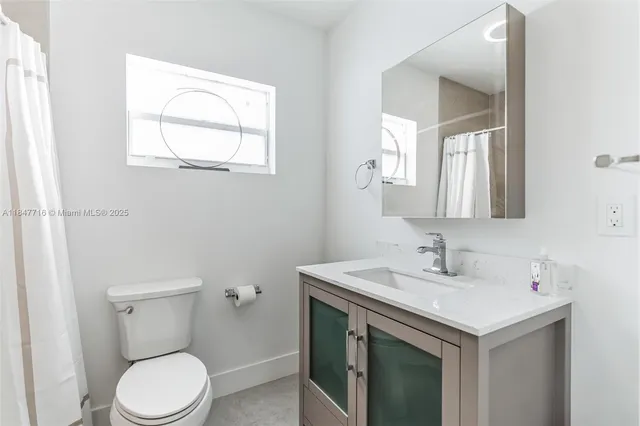 a bathroom with a sink toilet and mirror