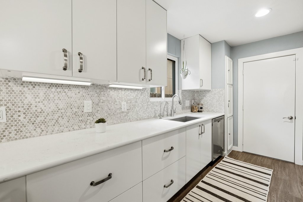 658 Mairo Street Austin, TX 78748 - Photo 9 of 40 Modern kitchen with white cabinetry and a mosaic tile backsplash.