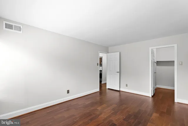 a view of an empty room with wooden floor