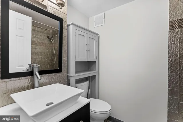 a bathroom with a toilet a sink and a mirror