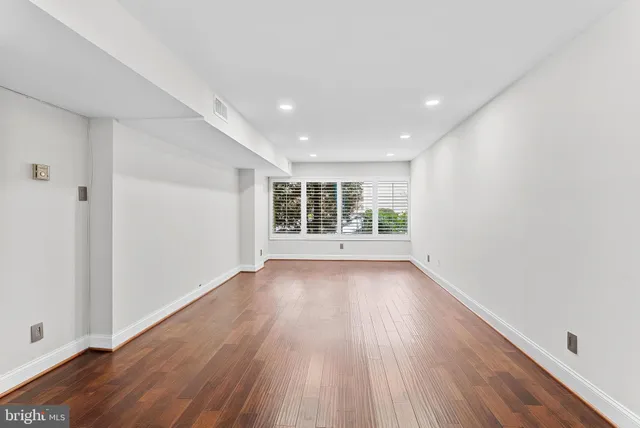 wooden floor in an empty room with a window