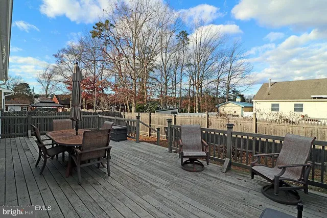 a view of a backyard with wooden fence and large trees