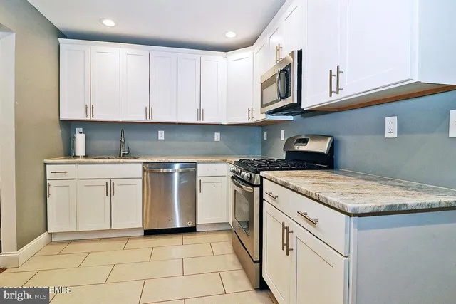 a kitchen with a stove sink and cabinets