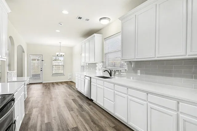 a kitchen with sink a stove and cabinets
