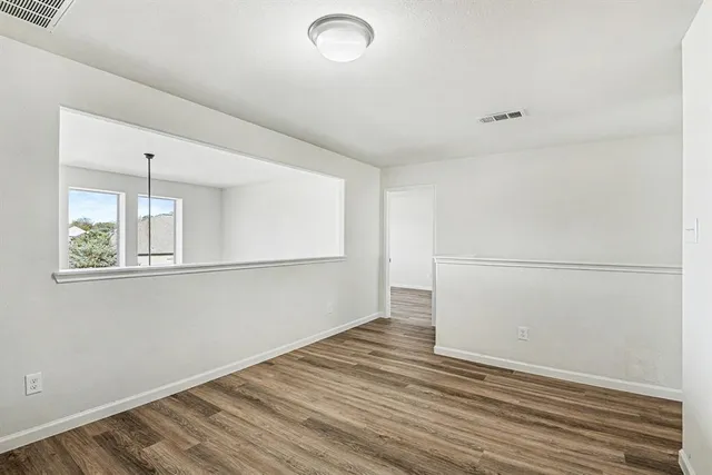 a spacious bedroom with a large bed a chandelier and windows