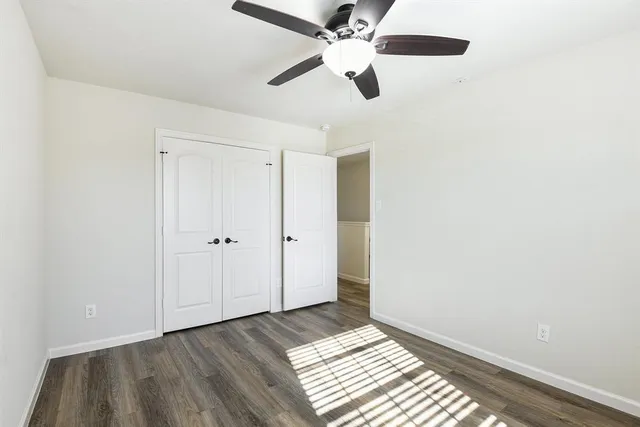 an empty room with wooden floor a ceiling fan and closet