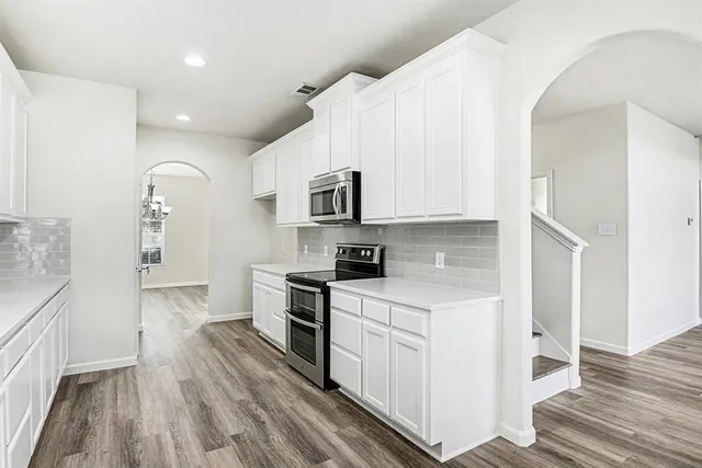 a kitchen with white cabinets and sink