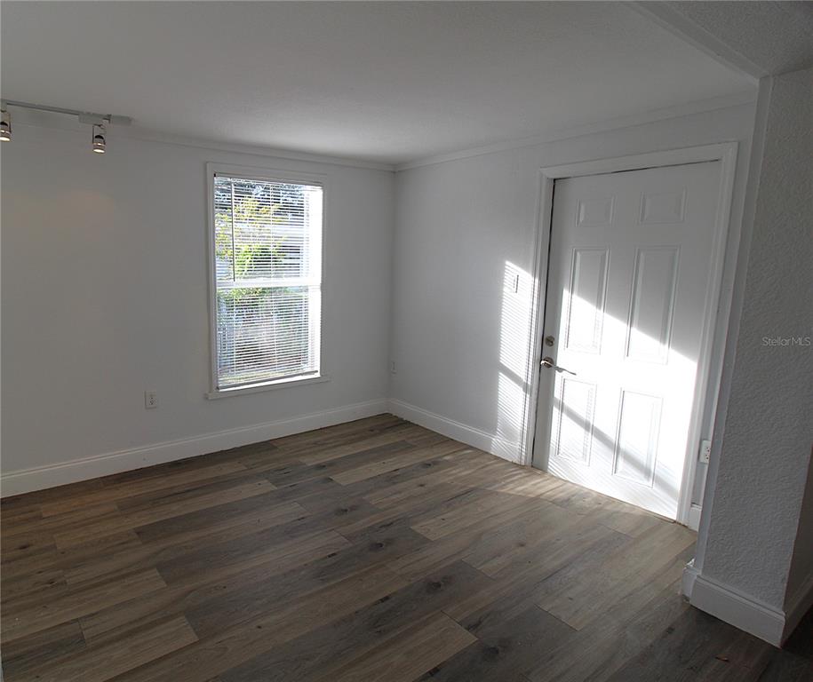 2345 Floyd Street Sarasota, FL 34239 - Photo 7 of 18 a view of an empty room with wooden floor and a window