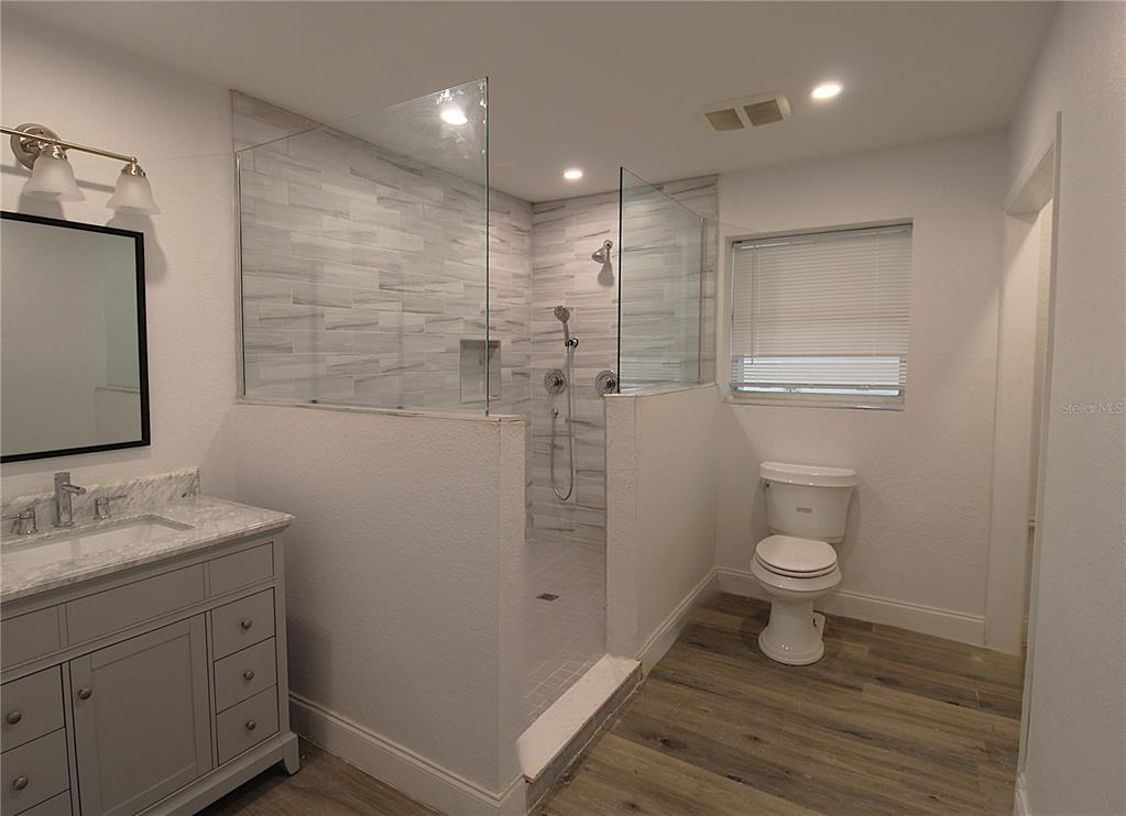 2345 Floyd Street Sarasota, FL 34239 - Photo 9 of 18 a bathroom with a granite countertop sink toilet and shower