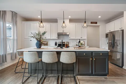 a kitchen with stainless steel appliances granite countertop a sink a stove a refrigerator and island with wooden floor