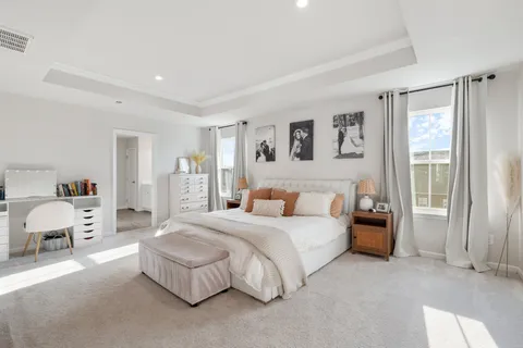 a spacious bedroom with a bed and a couch