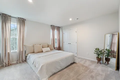 a bedroom with a bed and a potted plant