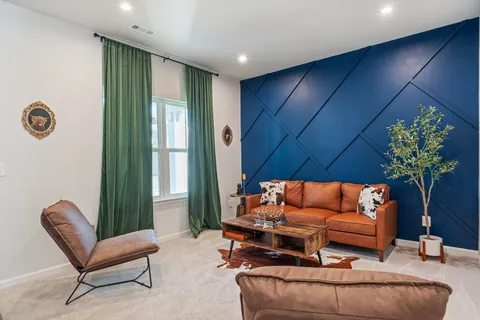 a living room with furniture a couch and a potted plant