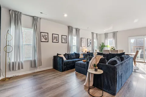 a living room with furniture a wooden floor and a large window