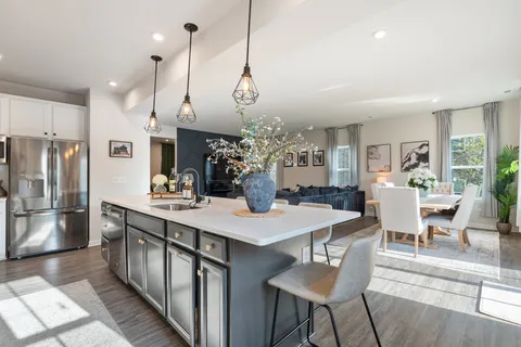 a large kitchen with granite countertop a stove a sink a oven a dining table and chairs