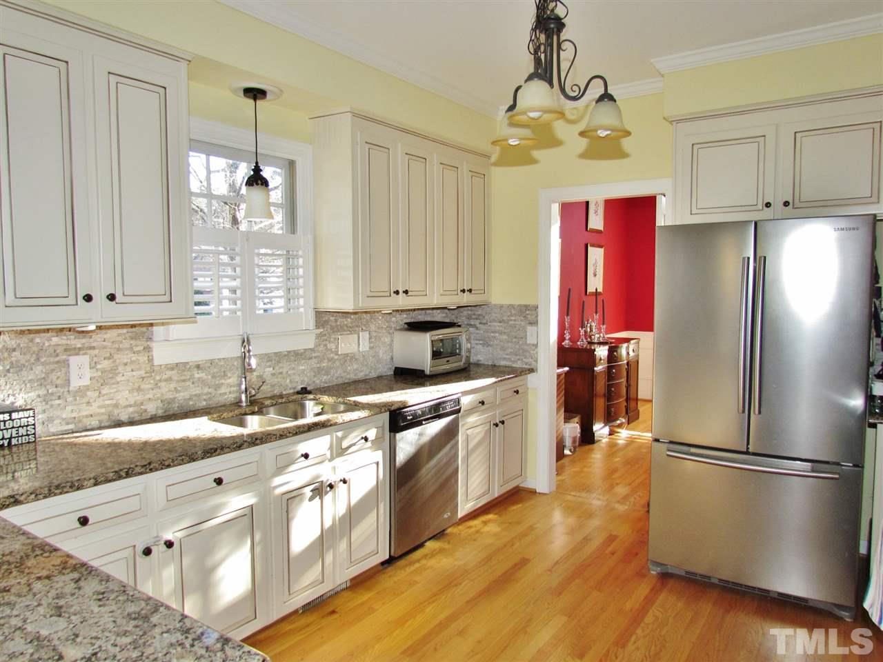 513 Tufts Court Raleigh, NC 27609 - Photo 10 of 25 a kitchen with stainless steel appliances granite countertop a refrigerator a sink dishwasher a stove with wooden floor and cabinets