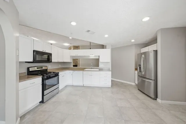 a kitchen with stainless steel appliances refrigerator and microwave