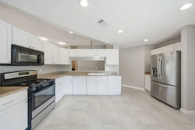 a kitchen with a refrigerator stove and microwave