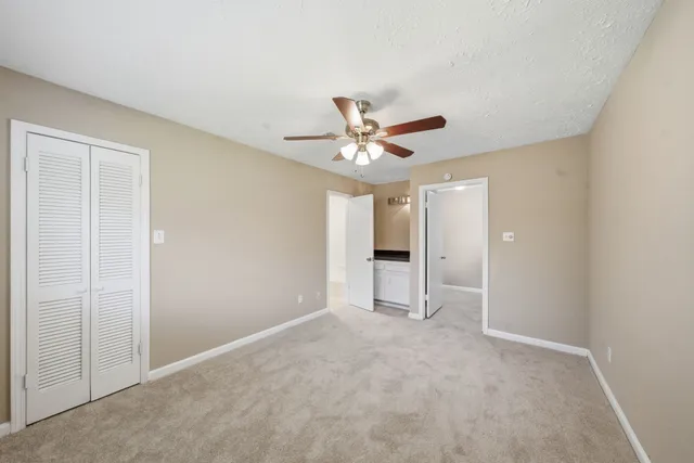 an empty room with closet and windows