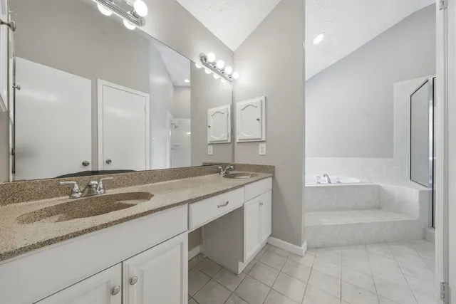 a bathroom with a granite countertop sink a toilet a large mirror and bathtub